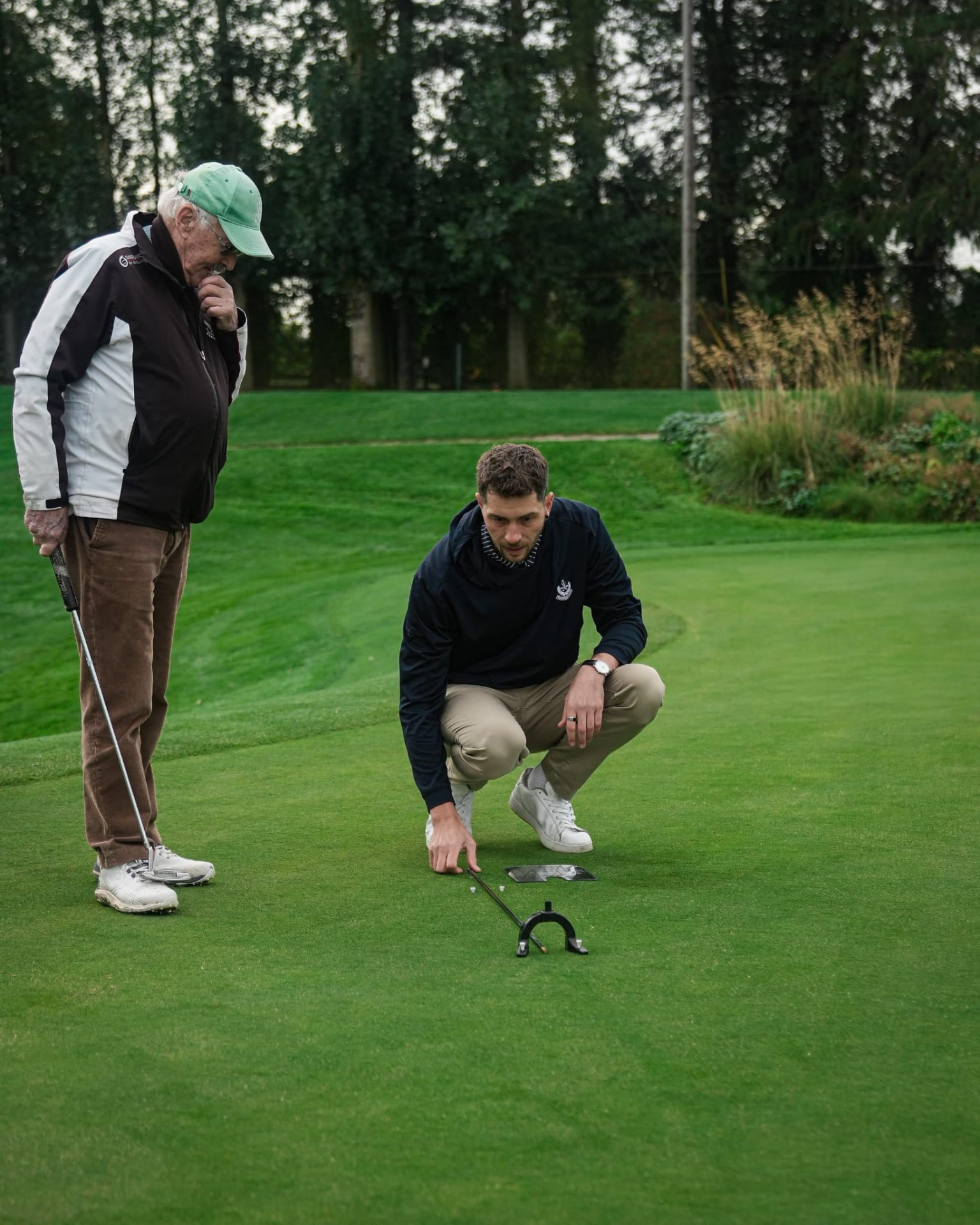 Shane Lee coaching a golfer on the practice green